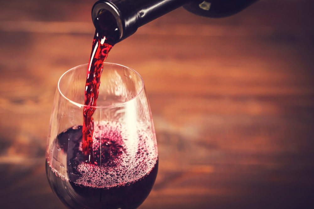 Pouring,Red,Wine,Into,The,Glass,Against,Wooden,Background wine event